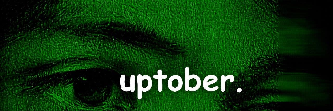 Close-up of an eye in green tones with the word "uptober."